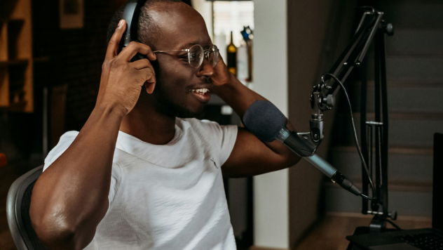 Man adjusting headphones in front of a microphone setup.