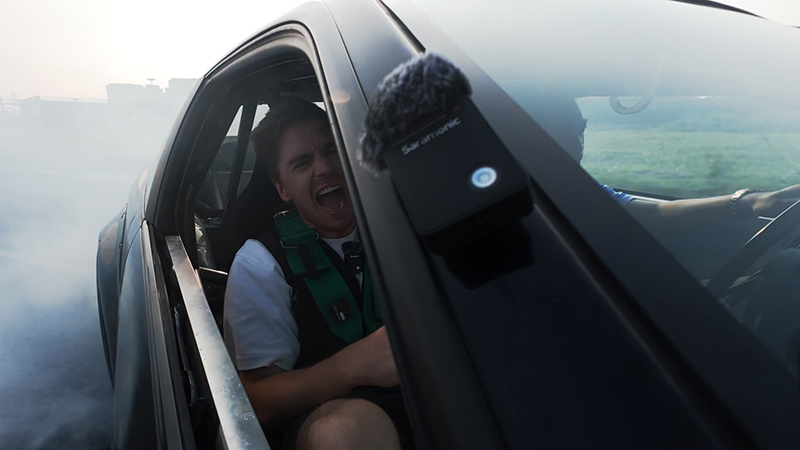 A young boy in a helicopter wearing a microphone for live streaming, capturing his excited expression.