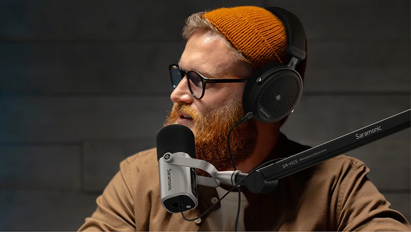 Bearded man recording podcast with Saramonic microphone.