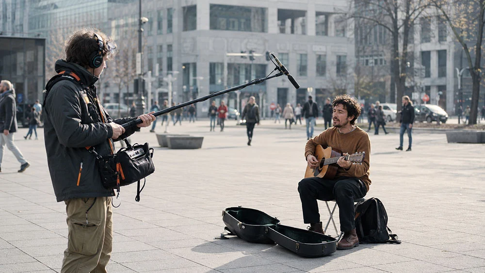 a professional documentary or field-recording scene in a modern outdoor city squar